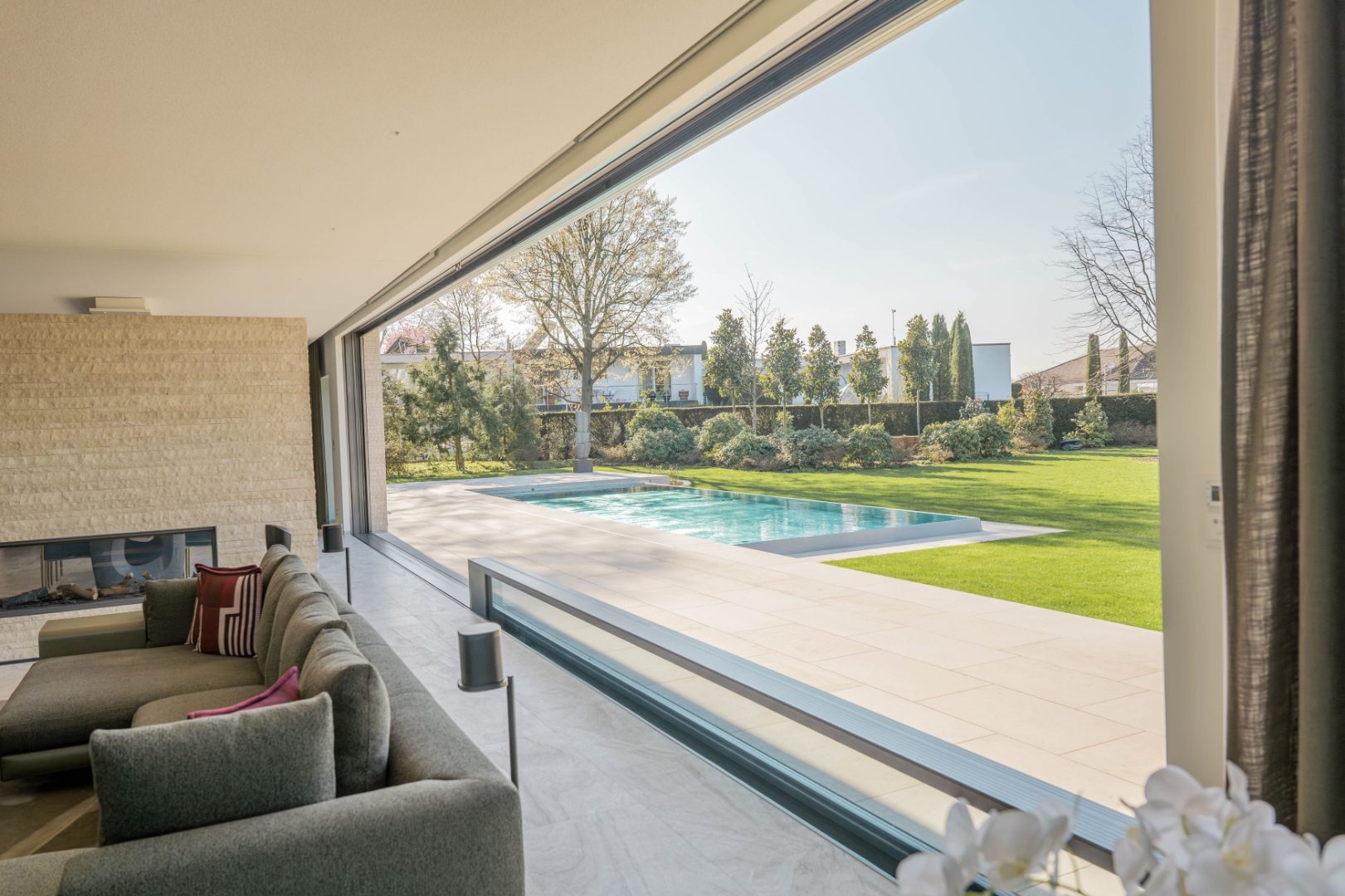 HIRT kinetics Senkfenster öffnet Wohnraum zum Garten mit Pool
